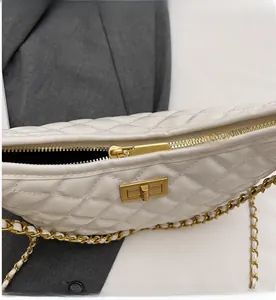 Detail view of smooth metal zipper and gold hardware on white quilted chain bag