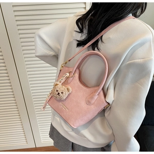Dettaglio borsa a secchiello in pelle PU rosa con ciondolo orsetto e sciarpa di seta a righe
