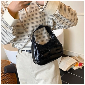 Sac croissant en cuir verni noir avec grand nœud et bandoulière chaîne argent