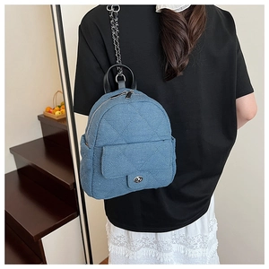 Blue denim quilted backpack featuring silver chain straps and metallic twist lock detail