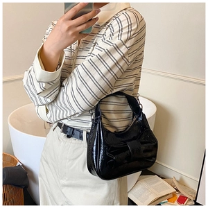 Sac croissant chic en cuir verni noir avec grand nœud porté à l'épaule pour femme