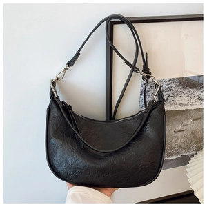 Close-up of black crescent shoulder bag featuring premium wrinkled leather and silver hardware