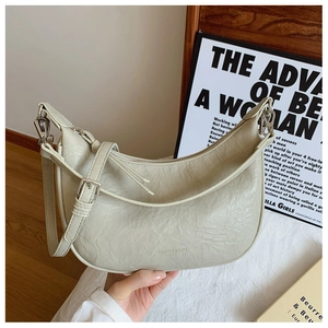 Detailed view of beige hobo bag showing wrinkled leather texture and silver hardware buckle