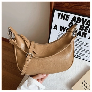 Detail of light brown wrinkled PU leather moon bag with adjustable silver buckle strap