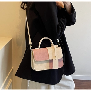 Detail showing pink and beige patchwork bag with woven texture and fashion tag
