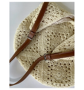 Close-up of crochet weave pattern with brown leather straps and fabric lining