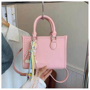 Pink lychee texture tote bag detail with pearl strap and rainbow tassel charm