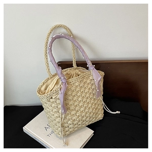 Detail of hand-woven beige bucket bag with lavender silk scarf and pearl handle decoration