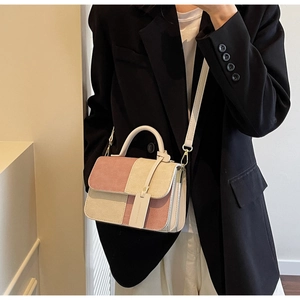 Detail of pink and beige patchwork crossbody bag with corduroy texture and top handle