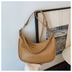Detail view of khaki faux leather crescent bag with adjustable strap and silver metal buckle