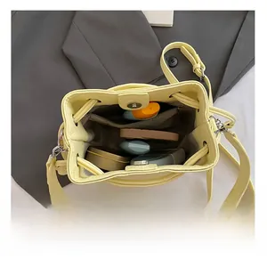 Internal view of yellow bucket bag with lychee texture and organized storage compartments