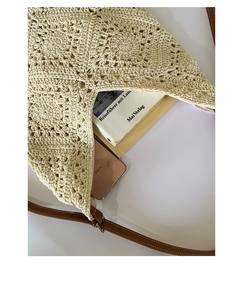 Detail of hollow woven tote bag with brown leather strap and spacious interior
