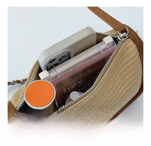 Detail view of woven cylinder bag interior with phone and cosmetics capacity