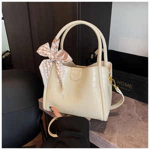 Détail du sac seau crème avec texture crocodile et foulard en soie décoratif