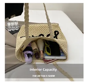 Vue détaillée de l'intérieur spacieux du sac cabas en paille avec articles du quotidien