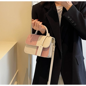 Detail of pink and cream patchwork crossbody bag with textured corduroy fabric and top handle