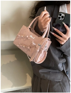 Sac à main rose en cuir verni avec des nœuds perlés et un logo métallique élégant