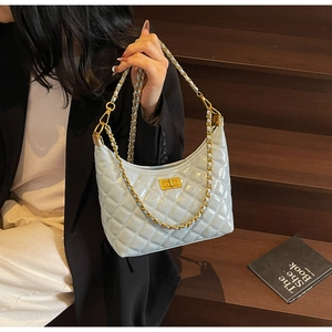 Close-up of light blue patent leather hobo bag with quilted pattern and gold chain strap