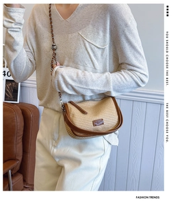 Close-up of beige woven crossbody bag with brown leather trim and metal chain strap