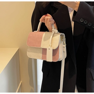 Close-up of pink and cream patchwork corduroy crossbody bag with golden hardware