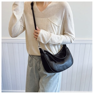 Detail of black crescent hobo bag featuring vintage wrinkled leather and silver hardware
