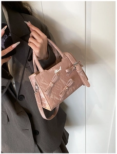 Détail d'un sac rose à texture marbrée avec nœud 3D et élégante perle décorative