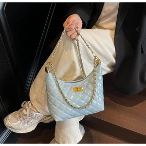 Detail of light blue patent leather hobo bag featuring quilted pattern and gold chain strap