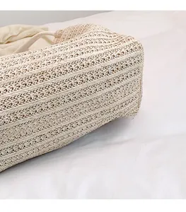 Macro shot of off-white woven straw tote texture with white rope handle detail