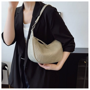 Detail of the pleated cream leather texture on the stylish crescent shoulder bag