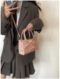 Détail du sac à main en cuir verni rose avec texture plissée et nœuds perlés