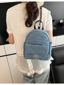 Quilted blue denim mini backpack with silver metal chain straps shown on model