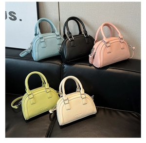 Détail de mini sacs bowling colorés en cuir grainé avec poignées et boucles argentées