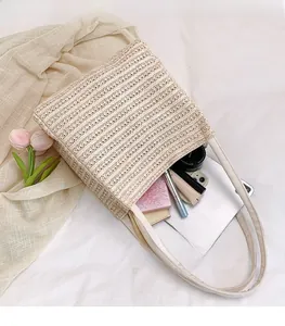 Detail showing the spacious interior of the beige woven tote bag with daily essentials