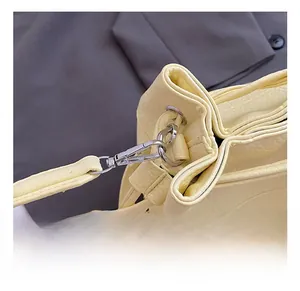 Detail of silver metal swivel hook and yellow lychee grain leather strap on bucket bag