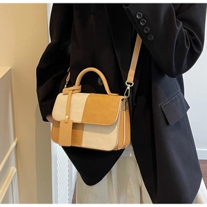 Detail of color-block crossbody bag with beige textured fabric and brown handle