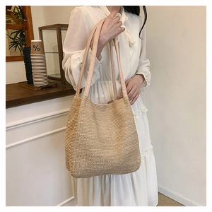 Detailed texture of hand-woven straw tote bag with fabric strap for beach vacations