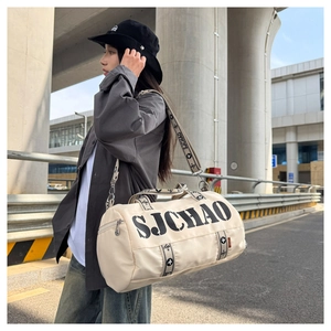 Close-up of beige travel bag showing SJCHAO logo branding and patterned shoulder strap