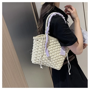Detail of woven straw bucket bag with purple silk scarf and pearl handle accents