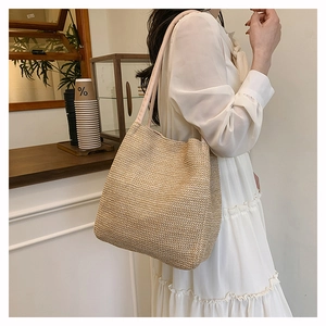 Close-up of a woven straw tote bag with wide straps and natural texture for summer