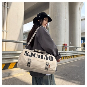 Outdoor shot of stylish cream canvas travel bag with SJCHAO logo and shoulder strap