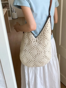 Borsa tote in crochet crema con manici in pelle marrone indossata da una modella