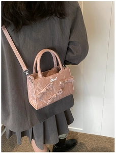 Détail du sac bandoulière rose marbré avec nœuds décoratifs et accents de perles