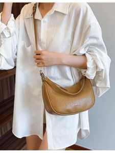 Caramel minimalist crescent crossbody bag with wrinkled leather texture and brand detail
