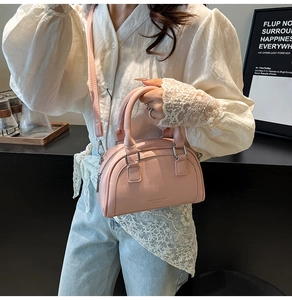 Détail du sac bowling en cuir litchi rose avec finitions argentées et embossage chic