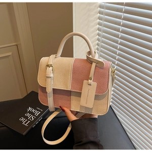 Detailed view of pink and beige patchwork crossbody bag with textured woven pattern