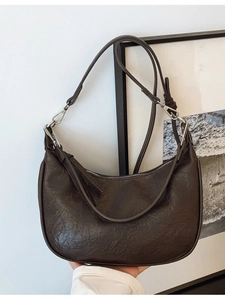 Dark brown crescent crossbody bag with pleated leather texture and adjustable strap