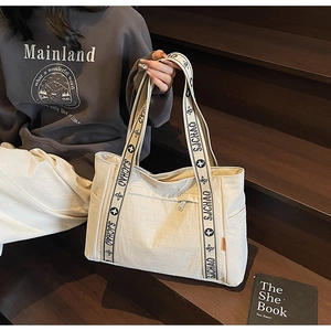 Detail of off-white tote bag with jacquard SJCHAO logo strap and side pockets