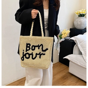 Détail du sac cabas en paille tissée avec broderie Bonjour noire dans un style rétro français