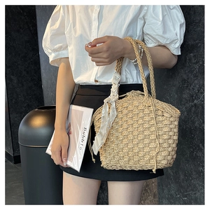 Detail of hand-woven straw bucket bag with pearl silk scarf handle and drawstring liner