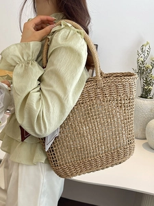 Beige hollow woven straw tote bag for summer beach vacation with cylindrical handles